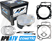 An assortment of motorcycle piston and gasket components, including a boxed piston kit, unboxed with visible piston and rings, and Cometic branded gaskets. The components are intended for use in a Honda CRF450R.